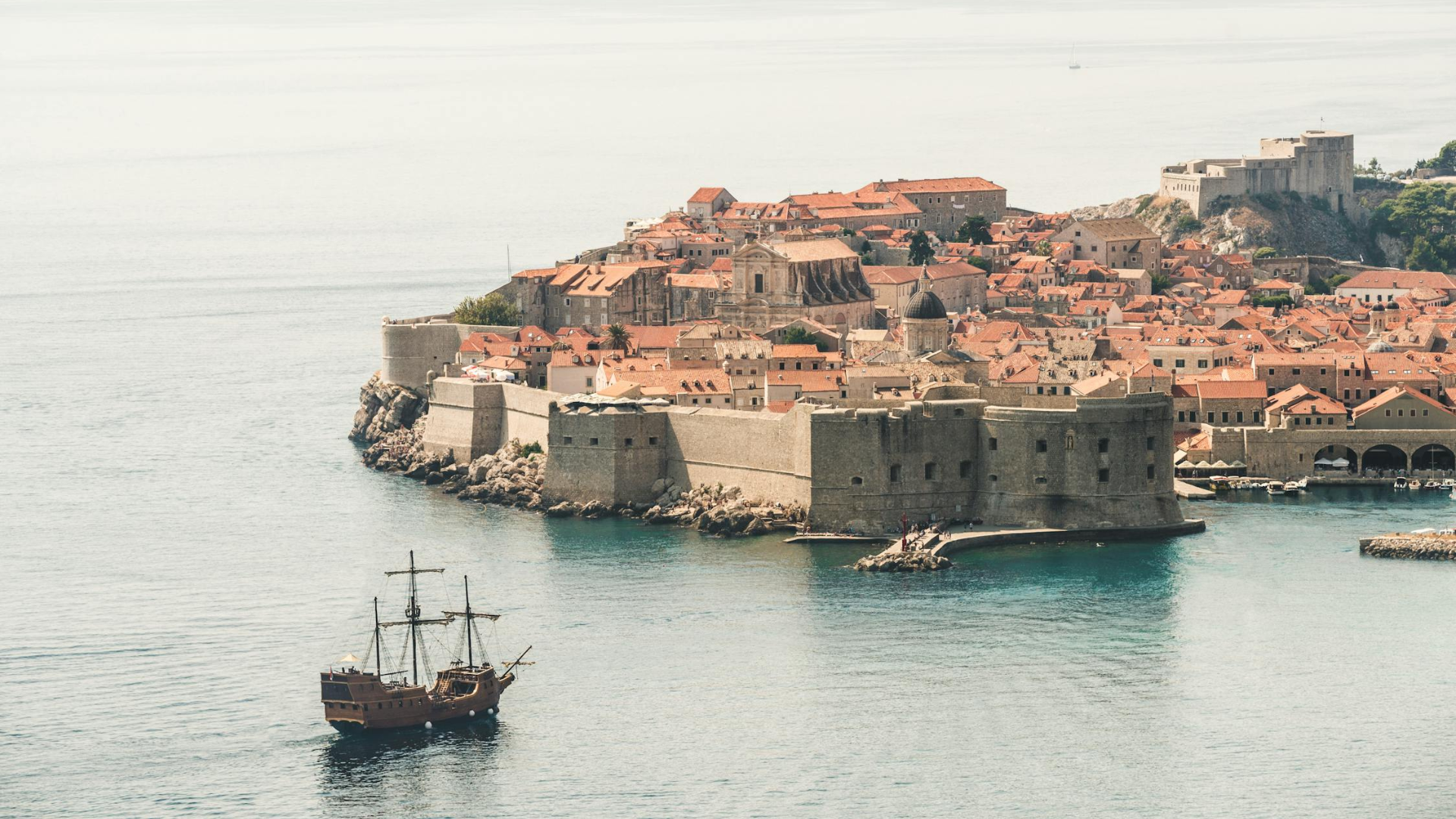 brown-sailing-ship-near-building