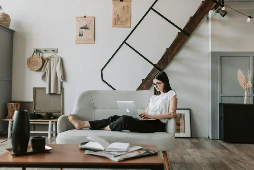 content-young-woman-using-laptop-in-modern-living-room