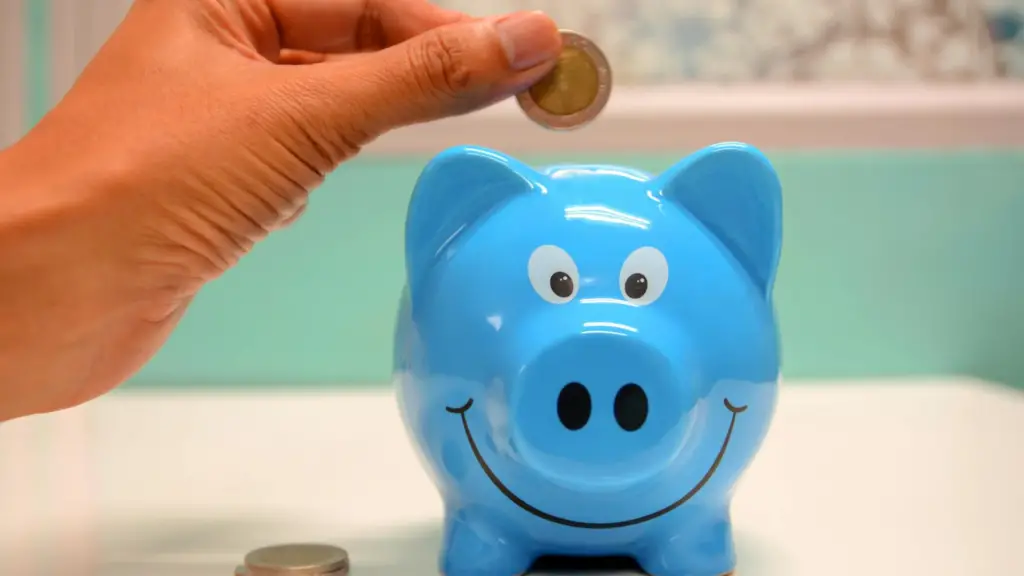 person-putting-coin-in-a-piggy-bank