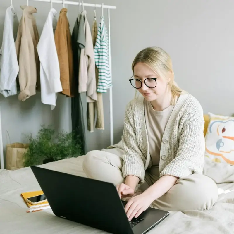 photo/photo-of-woman-sitting-on-bed-while-using-black-laptop