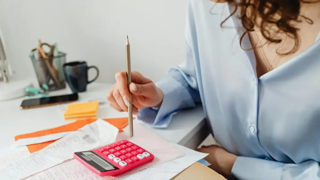 -woman-computing-bills-while-holding-a-pencil