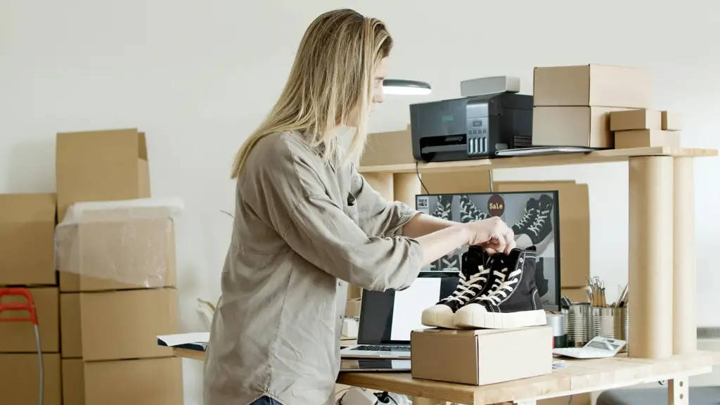 woman-holding-black-shoes-on-top-of-the-box